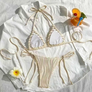 Détail d'un bikini crème avec texture ondulée et bordure en corde sur chemise blanche
