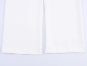 Detailed close-up of white linen blend trousers hem showing high-quality fabric texture