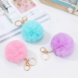 Detailed view of pink blue and purple fluffy plush unicorn keychains with golden hardware