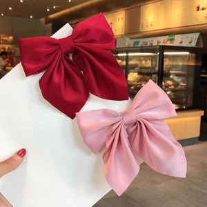 Pink and deep red satin bow hair clips shown on a display card in a sweet style