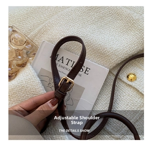 Detail of adjustable brown leather shoulder strap with a gold buckle for women's bags