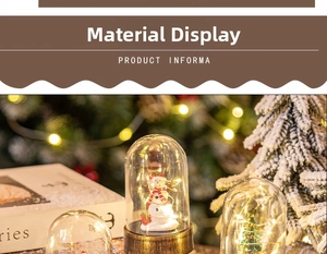 Detail of Christmas snowman glass dome with warm LED fairy lights on a wooden base