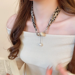 Détail du collier ras du cou léopard avec perle métallique et pendentif perle sur le mannequin