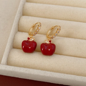 Dettaglio di orecchini a mela placcati in oro 18k con smalto rosso e zirconi