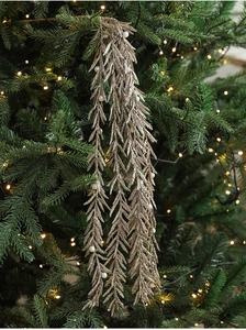 Glittery gold Christmas branches with pearls hanging on a lit Christmas tree