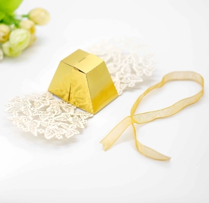 Macro view of white laser-cut butterfly candy box with gold prism body and ribbon detail