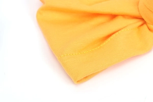 Macro detail of elastic yellow knitted fabric showing high-quality stitching and texture