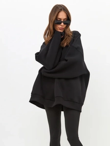 Close-up of oversized black fleece sweatshirt styled with sunglasses in a chic sporty look