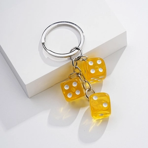Creative yellow resin dice keychain with silver metal ring on white display stand