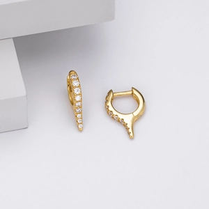 Detailed macro view of S925 sterling silver huggie earrings with gold finish and zircon