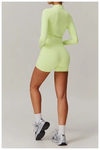 Eng anliegende fluoreszierend grüne Sportjacke mit Reißverschluss und kurze Sporthose