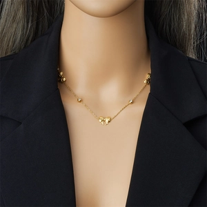 Elegant gold butterfly necklace with cubic zirconia accents on a model in dark suit