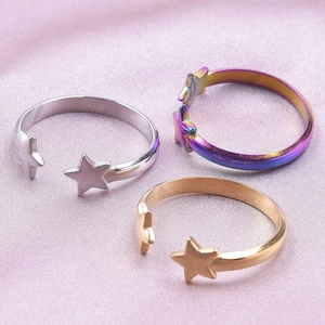 Adjustable stainless steel star rings in silver, gold and rainbow on pink silk fabric