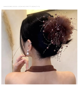 Détail d'une pince à cheveux fleur marron en tulle avec perles et glands décoratifs