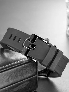 Macro shot of durable dark grey silicone watch strap with black metal folding buckle detail