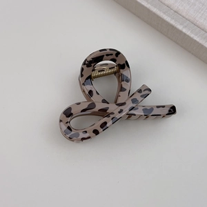 Detailed close-up of a leopard print claw clip with a glossy acetate finish and metal spring