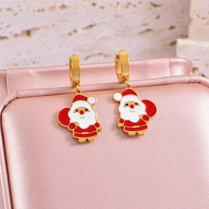 Detail view of Santa Claus enamel earrings hanging on a pink jewelry box for Christmas