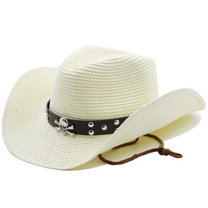 Détail d'un chapeau de cowboy en paille avec bande en cuir marron et emblème tête de mort