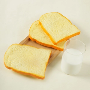 Tranches de pain grillé artificielles en PU sur plateau en bois avec bouteille de lait