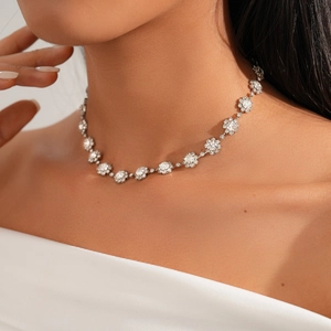 Close-up of elegant silver flower cluster necklace with zircon crystals on model