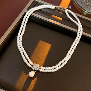Detailed view of vintage double-layer pearl necklace with a square diamond pendant and drop pearl