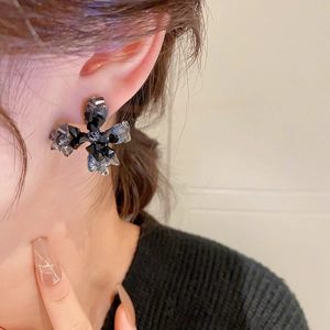 Gros plan de boucles d'oreilles fleur en cristal noir avec pierres sombres à facettes