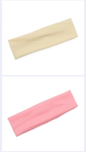 Flat lay of pink and beige fabric sports headbands on a clean white background