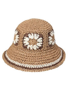 Close-up of handmade crochet straw hat featuring white flower patterns and textured weave