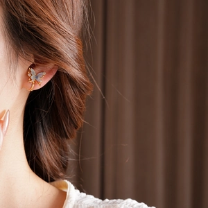 Detailed close-up of butterfly ear cuff with 18k gold plating and blue cubic zirconia