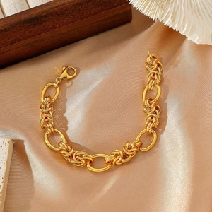 Gold chunky chain bracelet with mixed oval and braided links on beige satin display