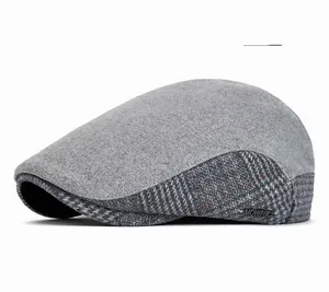 Detail of light gray wool blend ivy cap with plaid stitching and MONRID metal plaque