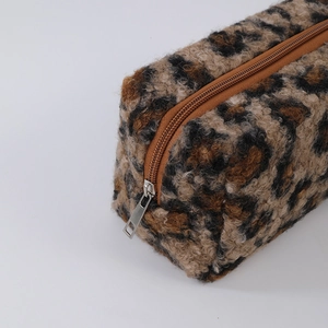 Detail of leopard print plush pouch with smooth metal zipper and soft fuzzy texture