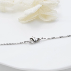 Polished titanium steel twist chain with lobster clasp on minimalist white background