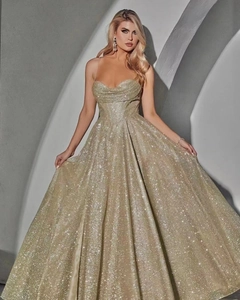 Detail of champagne gold evening dress with glitter fabric and elegant tiered hem