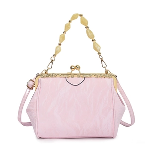 Detail of pink seashell bag with pleated texture and beaded handle with gold kiss-lock