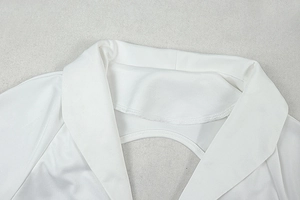 Détail du col à revers blanc avec découpe au dos sur le haut en tricot à manches longues