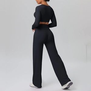 Detail view of black long-sleeve yoga crop top and high-waisted wide-leg sports pants