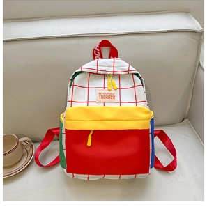 Detail of a colorful checkered canvas backpack for kids featuring red and yellow accents