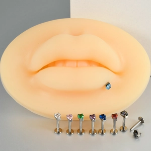 Detail view of heart-shaped zircon lip studs in multiple colors on a lip model