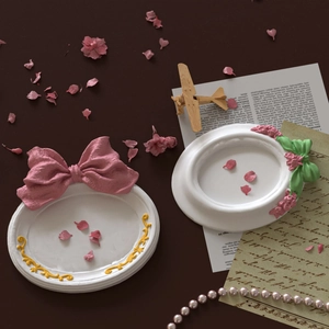 Macro shot of oval resin tray molds featuring 3D bow and floral relief details