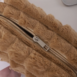 Close-up of the smooth metal zipper and soft brown plush texture on the pencil case