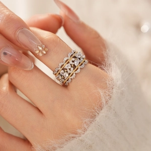 Detail of zircon lace hollow ring showing silver and gold contrast on a model's hand