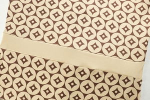 Macro detail of the stretch fabric showing beige and dark brown geometric star patterns