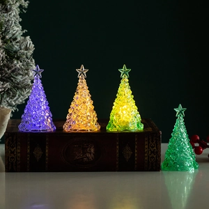 Mini glowing crystal Christmas trees in four colors on a vintage book for holiday decor