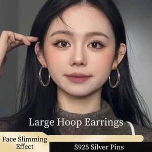 Front view of large polished silver hoop earrings with S925 silver posts on a model