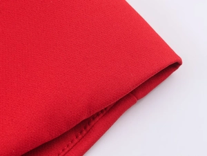 Macro view of bright red textured fabric detail with high-quality stitching on a skirt suit