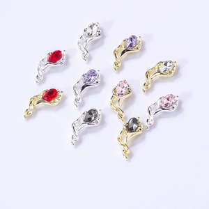 Macro detail of alloy nail charms with horse-eye crystals in gold and silver plating