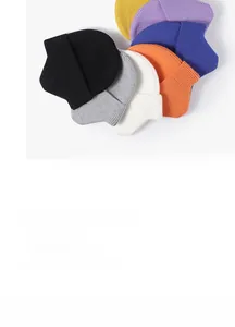Flat lay display of colorful ribbed knit beanies in black, gray, cream, and vibrant tones