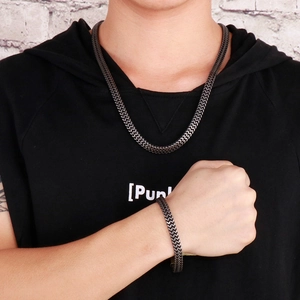 Close-up of a model wearing a black stainless steel snake chain necklace and bracelet set