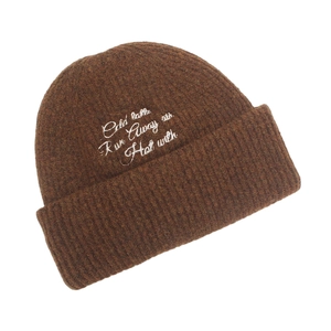 Close-up of deep brown chunky knit beanie with white letter embroidery detail